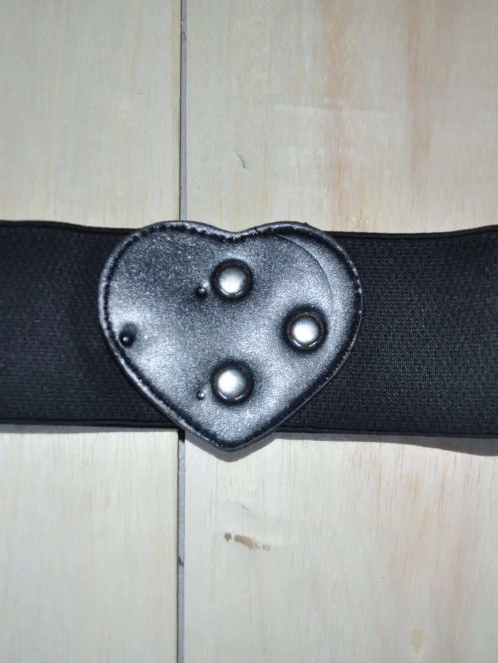 women's black elastic waistband belt features a distinct faux leather heart-shap
